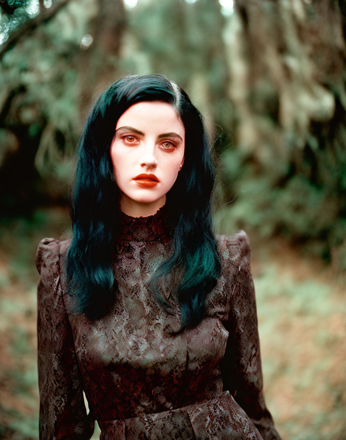 Black-haired woman in lace dress with red lipstick in forest scene