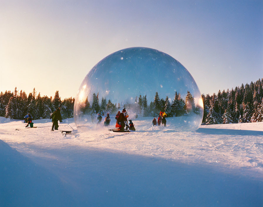 Group snow sledding in transparent bubble on snowy landscape