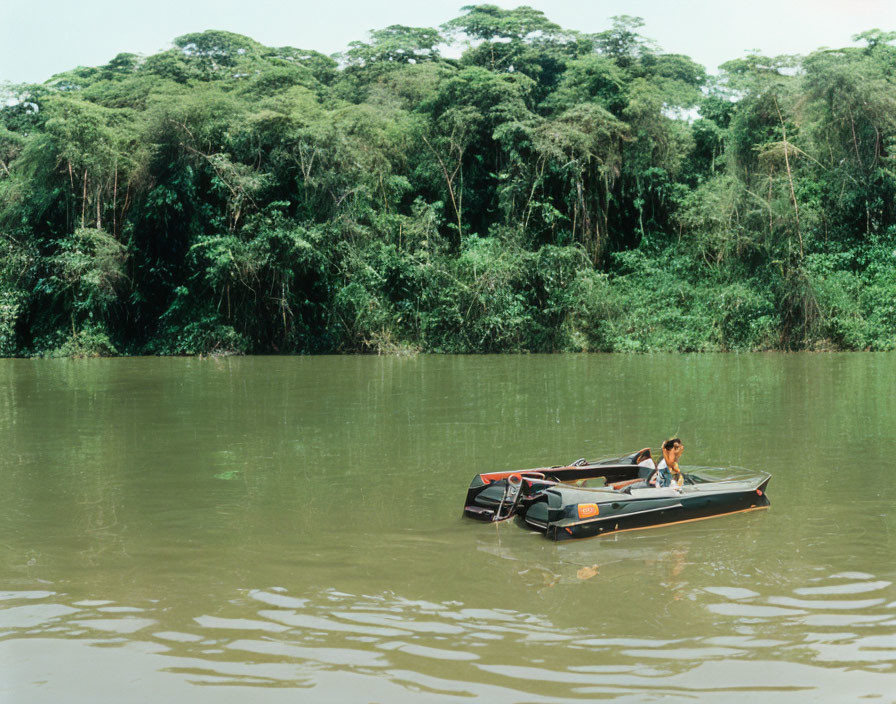 Person in Boat on Calm River with Lush Green Trees