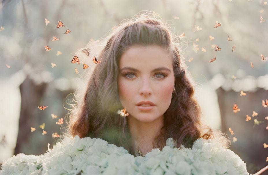 Woman with Long Hair Surrounded by Flying Butterflies in Soft-lit Natural Scene