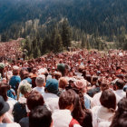 Forest clearing outdoor gathering with figures addressing crowd in red and blue attire