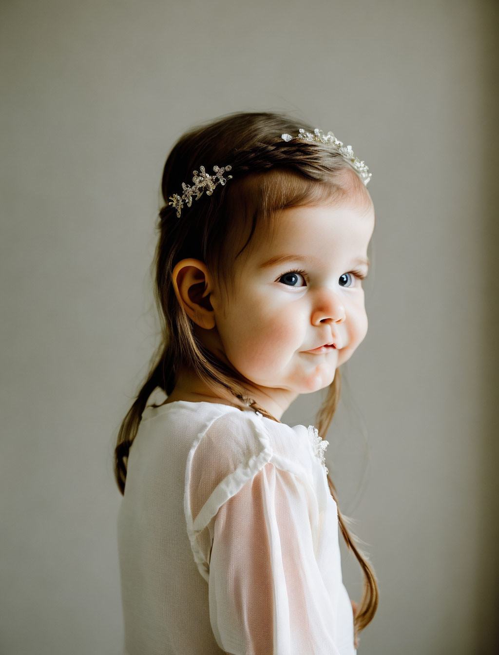 Toddler wearing a floral headband in soft lighting