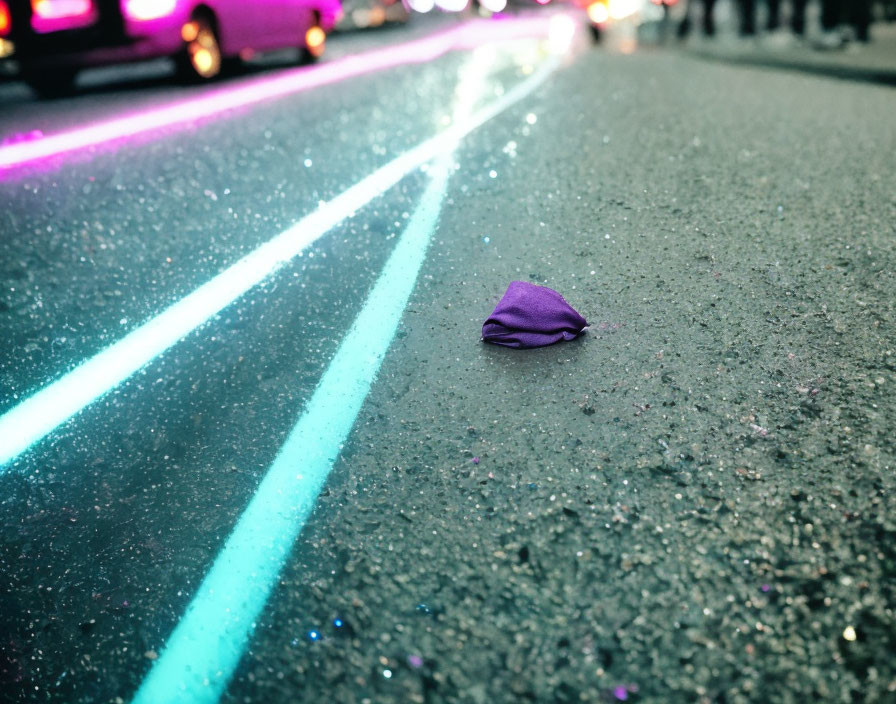 Purple Cloth on Wet Asphalt Road with Neon Light Reflections