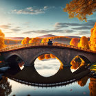 Autumn scene: Two people on stone bridge under sunset sky