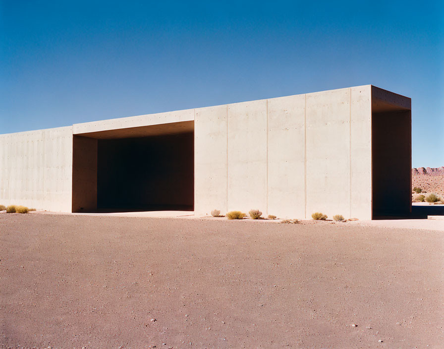 Concrete building with rectangular opening in desert landscape