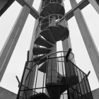 Ornate golden spiral staircase with cosmic patterns and planetary images in modern white structure