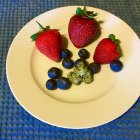 Vibrant Strawberries with Golden Stems on Decorative Plate