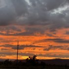 Vibrant sunset landscape with swirling sky and silhouetted elements