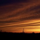 Sailing ship on vivid ocean at sunset with fiery clouds