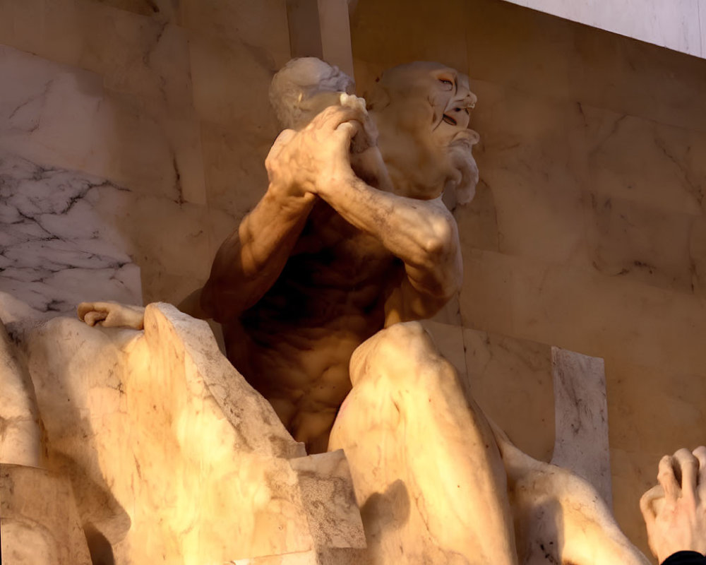 Muscular male figure holding up another against warm-colored stone