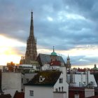 Gothic Cathedral Spire Over City Buildings at Sunset