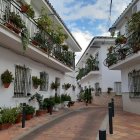 Charming cobblestone alley with white houses and flowers