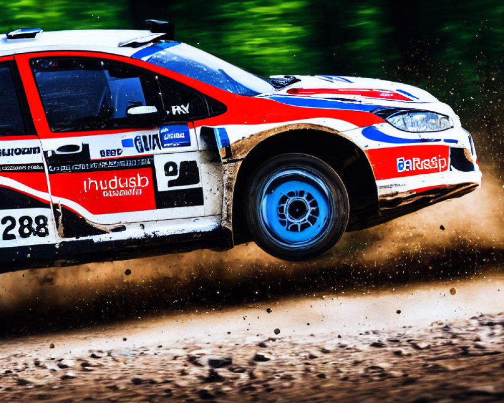 Red and white rally car speeding on dirt track, kicking up dust.