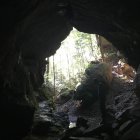 Ghostly figures in shadowy cave with dim light source