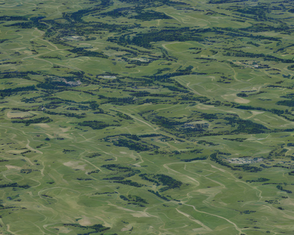 Green Patchwork Landscape with Rolling Hills and Snow-Capped Mountains