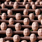 Terracotta figures with unique smiling faces under sunlight