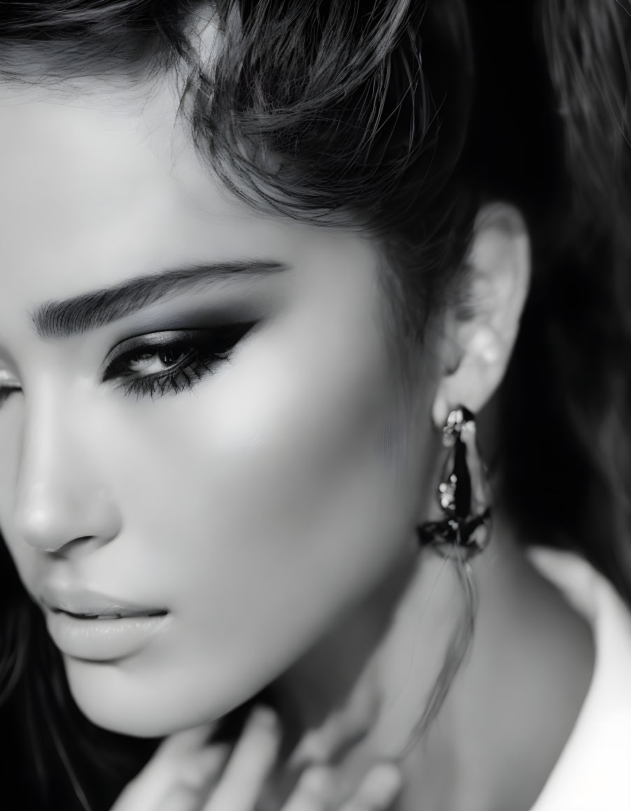 Monochrome close-up portrait of woman with bold eyeliner and elegant earring