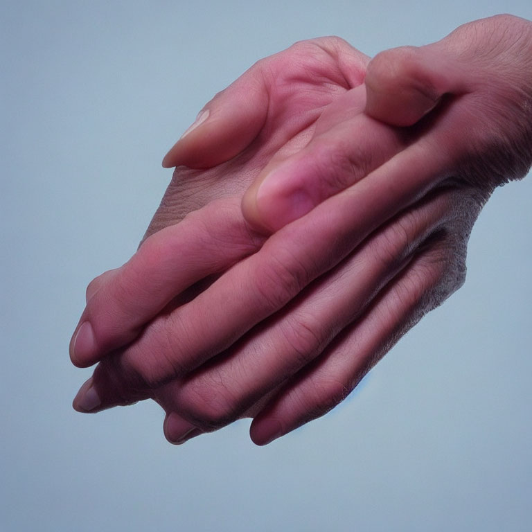 Human hands clasped in togetherness on blue background