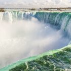 Illustration of vast waterfall, blue waters, golden hills, calm sky