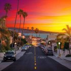 Stylized sunset landscape with vintage car, trees, houses & warm hues