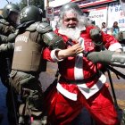 Group of tough bikers with Santa Claus and tattoos on motorcycle.