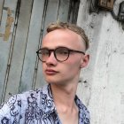 Stylized image of boy with large glasses in front of grunge metal door