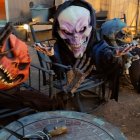 Skeleton Decorations with Glowing Pumpkin Heads Gather Around Autumnal Table