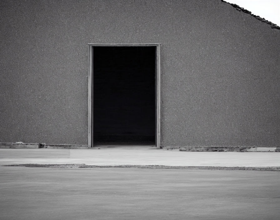 Spacious doorway in textured building exterior with dark interior.