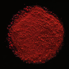 Vivid red powder with particles and specks on black background