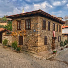 Rustic stone-paved village with wooden houses and greenery