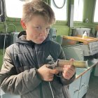 Young boy assembling intricate devices in steampunk room