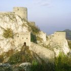 Medieval hilltop fortress with towers and lush surroundings