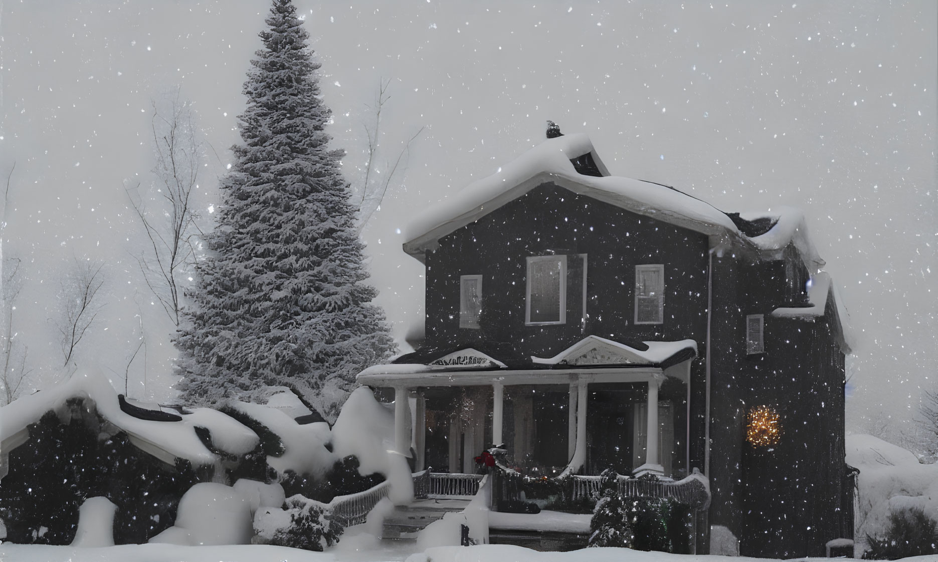 Snow-covered two-story house in heavy snowfall with illuminated porch