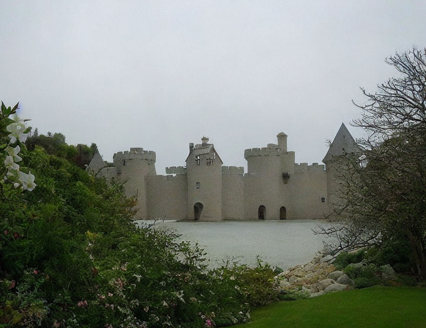 Majestic stone castle with turrets by calm water