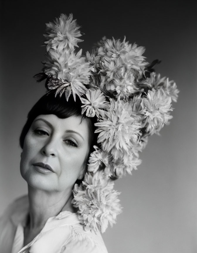 Monochrome portrait of woman in floral headpiece with closed eyes