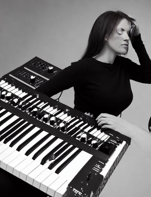 Contemplative woman with closed eyes beside a synthesizer keyboard