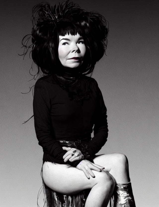 Smiling woman with unique makeup and voluminous hair in monochrome portrait