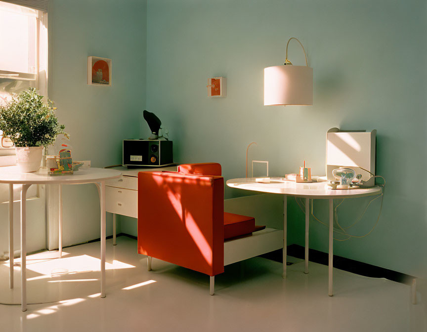 Bright sunlit room with light blue walls, white desk, red chair, plants, and modern décor