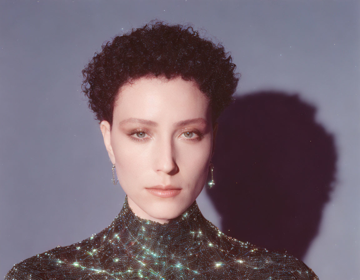 Short Curly Hair Person in Sparkling Turtleneck and Earrings with Shadow