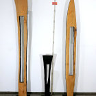 Trio of Tall Sculptures on Checkered Floor Displayed Against White Wall