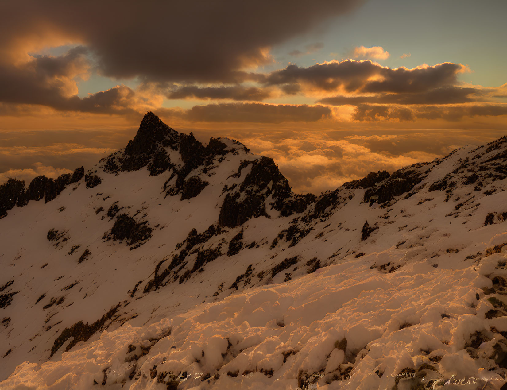 Snow-covered peaks in dramatic sunset mountain landscape