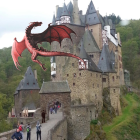 Medieval Castle on Hill with Towers, Moss-Covered Walls, Autumn Trees, and Blue Dragon