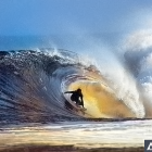 Colorful Surfer Riding Wave with Mountain Backdrop