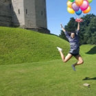 Colorful Balloons Held by Woman in Surreal Landscape