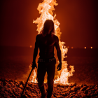 Person in headband walking towards towering flame amid debris