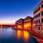 Illuminated Venetian canal at twilight with reflecting buildings and moored boats