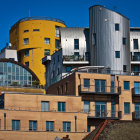 Geometric Urban Landscape in Yellow, Brown, and White Against Blue Sky