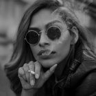 Monochrome artistic image of woman with flowing hair and star-adorned glasses