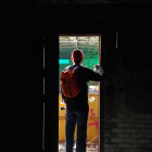 Silhouetted figure in red shirt against vibrant room with green and yellow hues