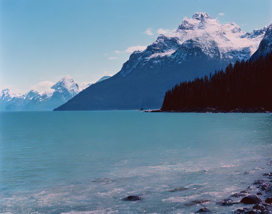 Snowy Alpine Lake Surrounded by Mountains and Forests